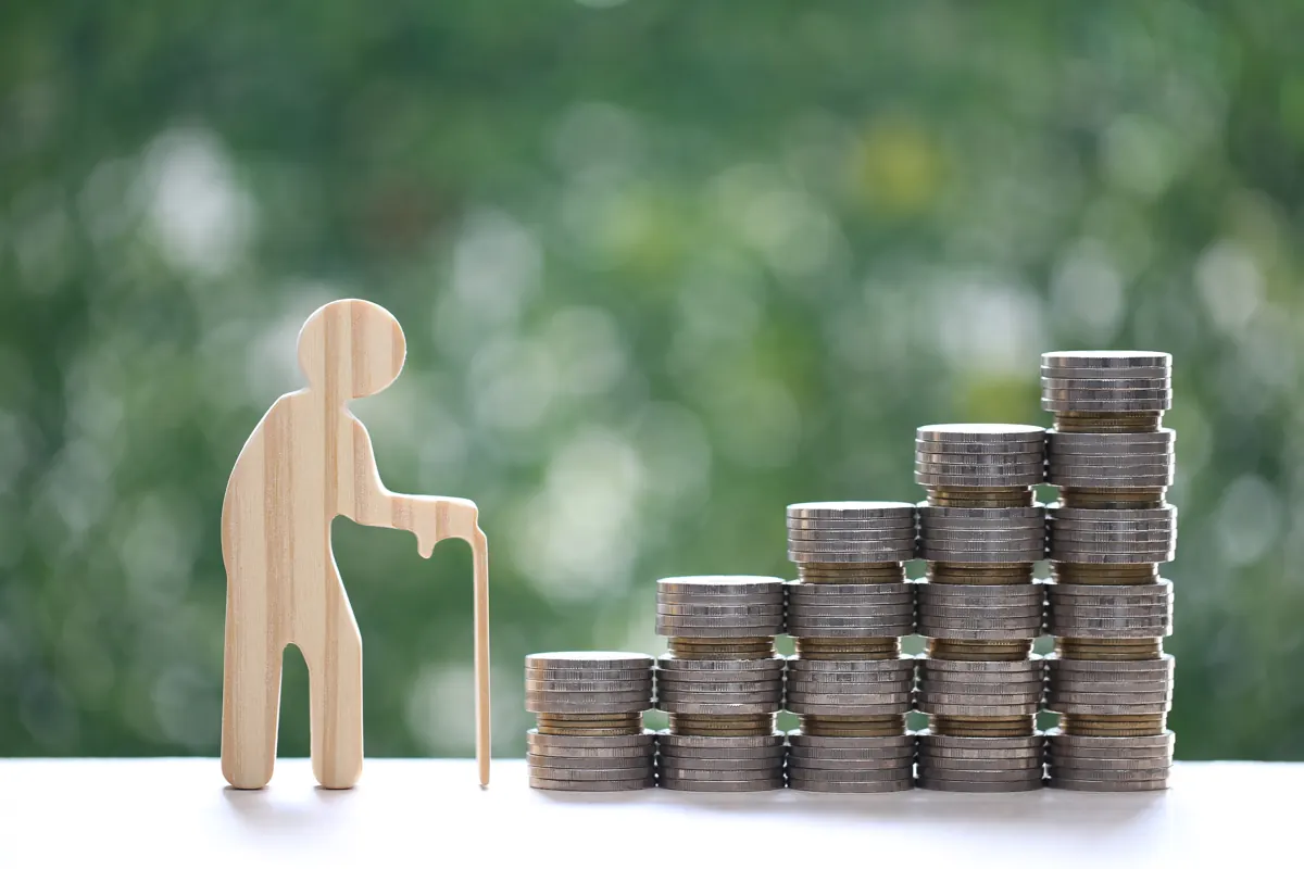 Figura de madeira ao lado de pilhas de moedas crescentes